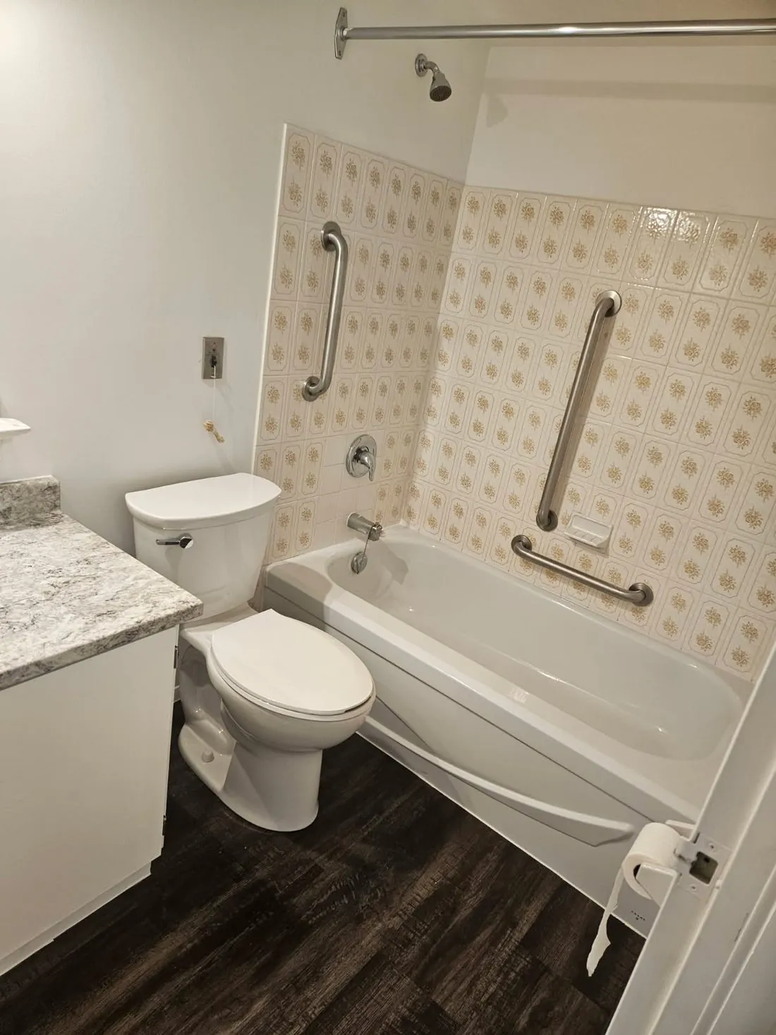 A finished accessible bathroom with grab bars and a toilet in Belleville, Ontario