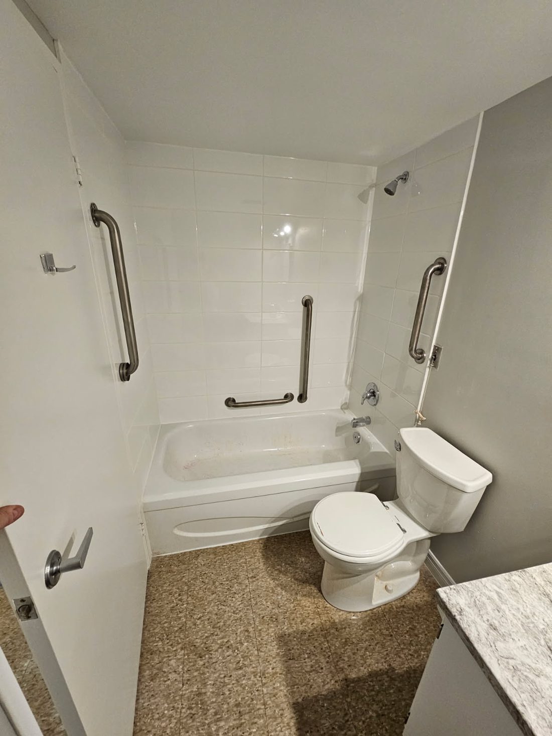 An accessible bathroom with a tub cut-out and grab bars in Brighton