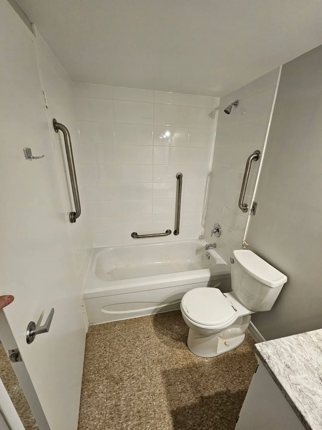 An accessible bathroom with a tub cut-out and grab bars in Brighton