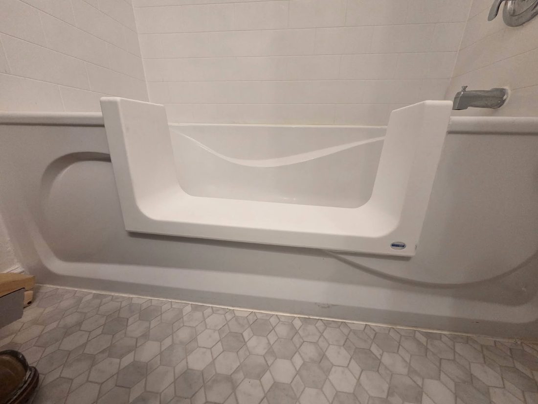 A finished low tub cut-out conversion with a grab bar in a Frankford bathroom